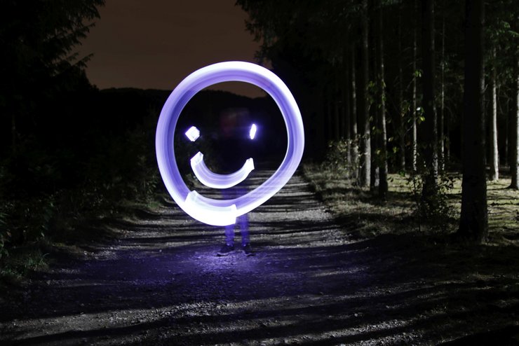 Lightpainting-Foto: Mit Licht gemaltes Smiley in einer dunklen Umgebung